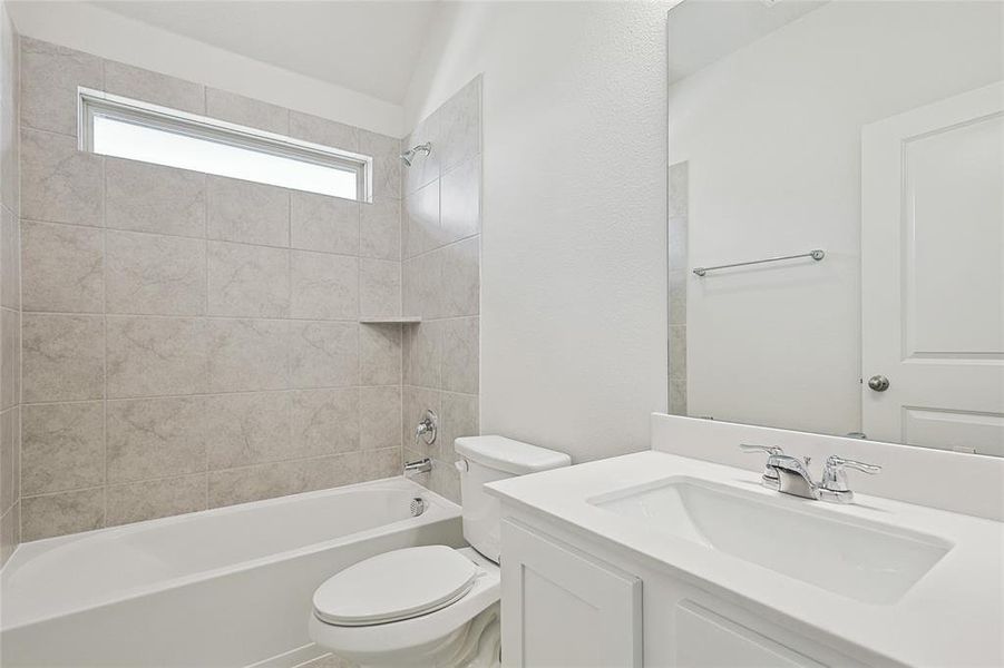 Full bathroom with toilet, vanity, and tiled shower / bath