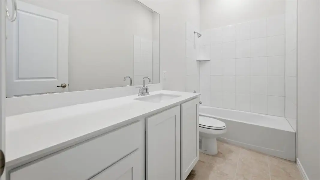 Bathroom with vanity, shower / bathtub combination, and light tile patterned flooring