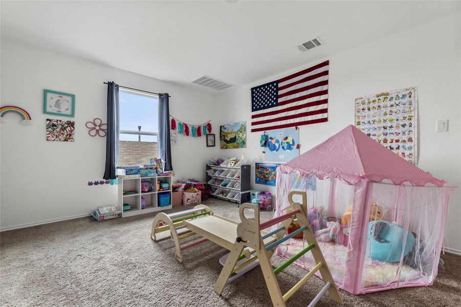 A well-lit play space features soft carpeting and ample natural illumination from a large window.