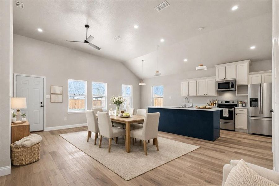 Dining area with light wood finished floors, a ceiling fan, plenty of natural light, lofted ceiling, and recessed lighting