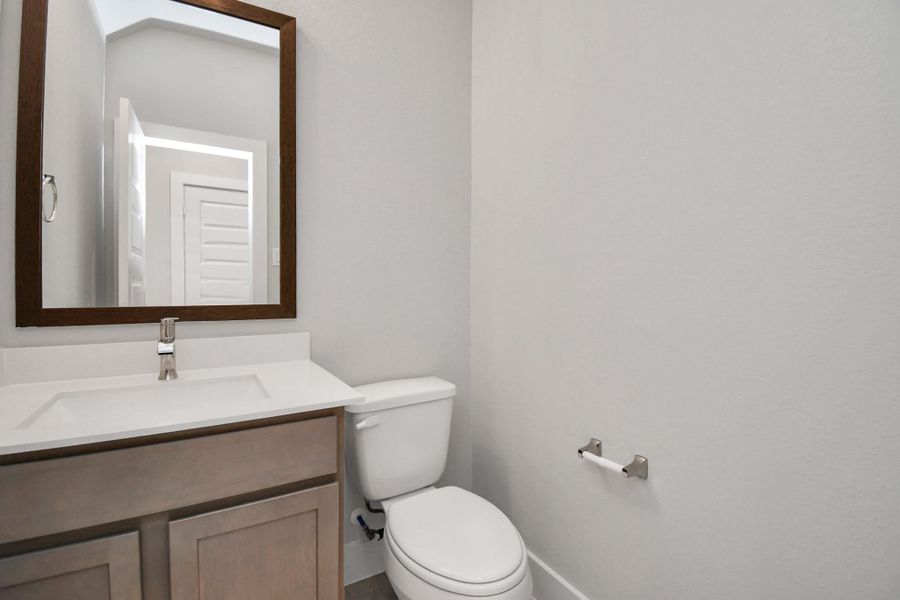 Delightful half bathroom featuring a sophisticated 5-panel door, upgraded sink, contemporary hardware, and bright recessed lights. Sample photo of completed home with similar floor plan. Actual colors and selections may vary. Delightful half bathroom featuring a sophisticated 5-panel door, upgraded sink, contemporary hardware, and bright recessed lights. Sample photo of completed home with similar floor plan. Actual colors and selections may vary.