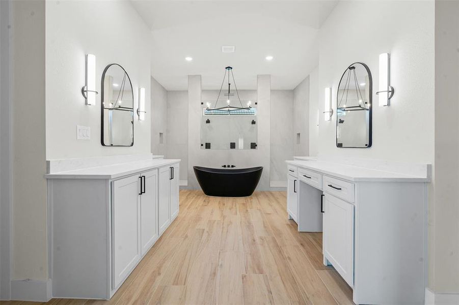 Bathroom featuring light wood-type flooring, two vanities, a soaking tub, recessed lighting, and walk in shower Bathroom featuring light wood-type flooring, two vanities, a soaking tub, recessed lighting, and walk in shower