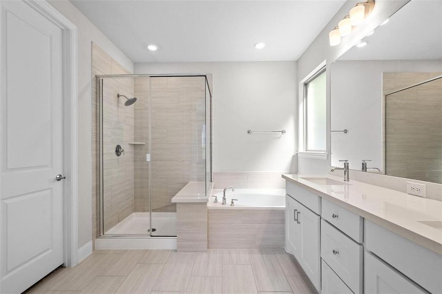 Bathroom featuring vanity and independent shower and bath