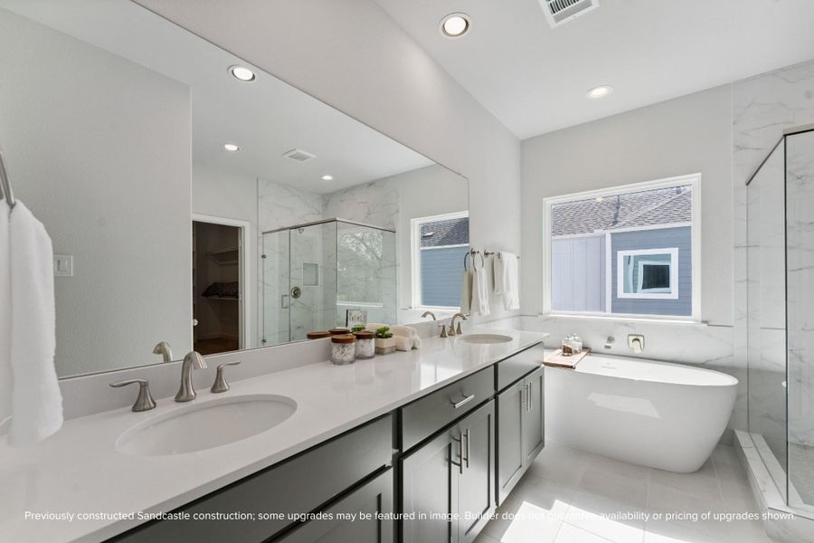 Spa-Like Primary Bathroom – Indulge in luxury with a freestanding soaking tub, herringbone-tiled shower, and double vanities with quartz countertops.