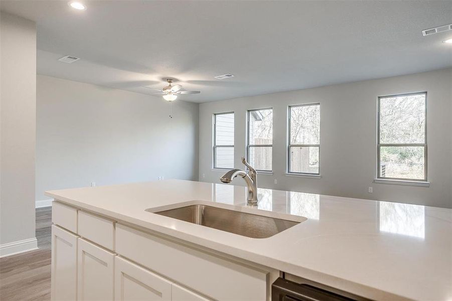 Kitchen featuring white cabinetry, ceiling fan, light hardwood / wood-style floors, and sink