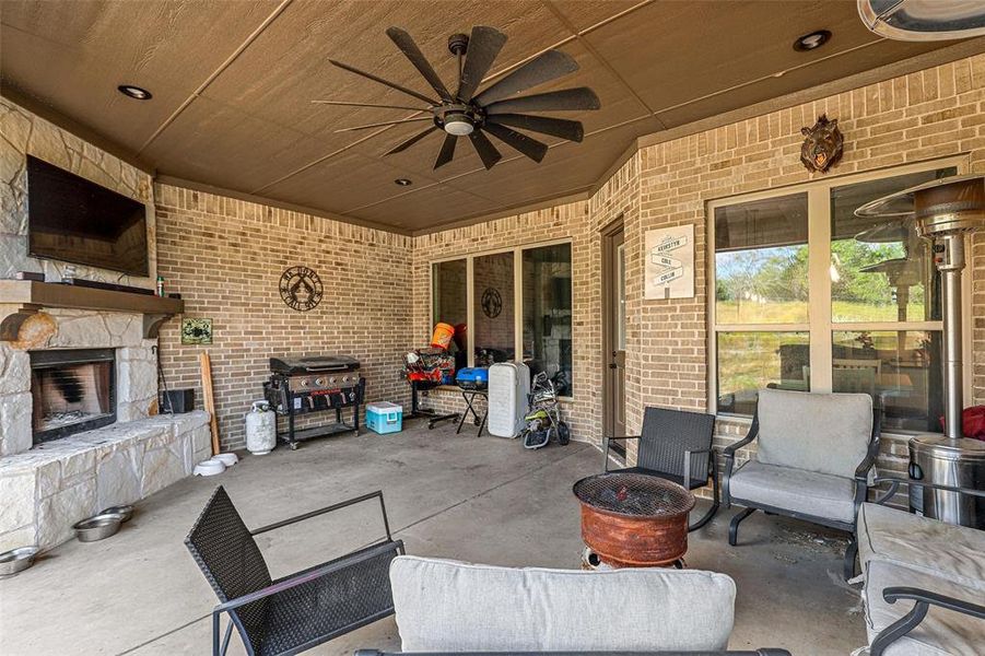 View of patio featuring ceiling fan and an outdoor stone fireplace