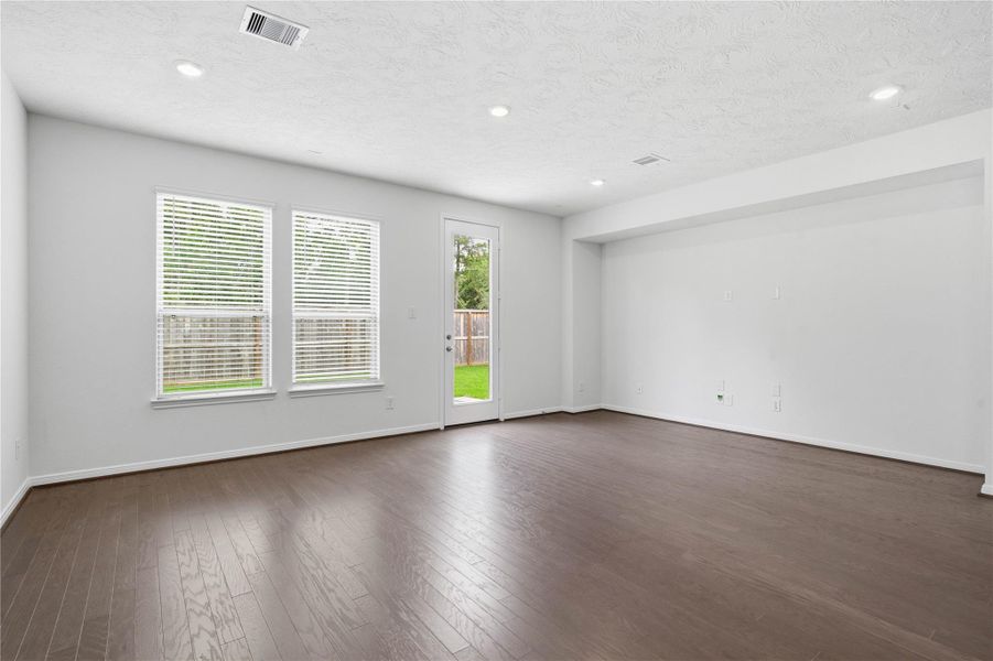 Bring family and friends together in this beautiful family room! It features high ceilings, recessed lighting, custom paint, stunning engineered wood flooring in Aegean Oak, access door to the back patio, and large windows that fill the space with natural light all day long. Bring family and friends together in this beautiful family room! It features high ceilings, recessed lighting, custom paint, stunning engineered wood flooring in Aegean Oak, access door to the back patio, and large windows that fill the space with natural light all day long.