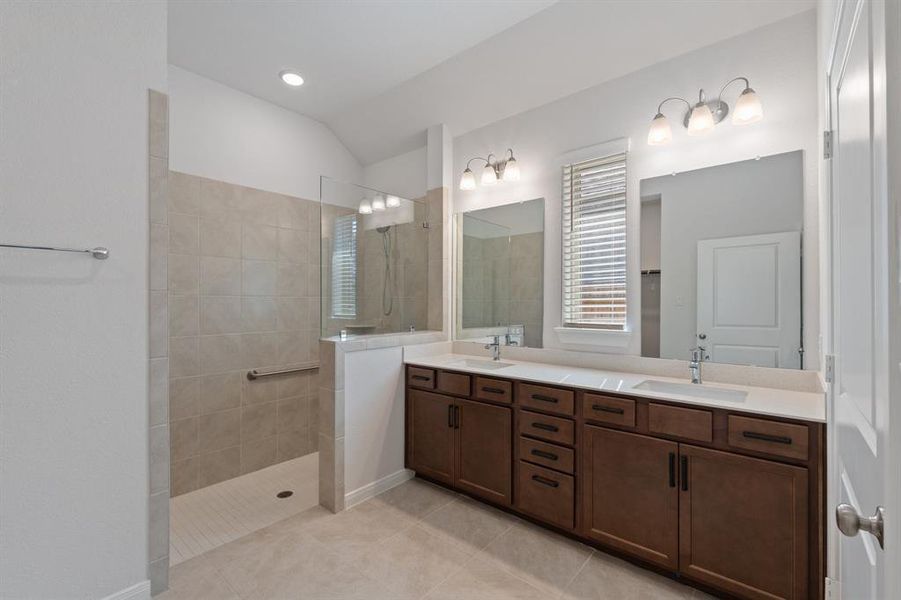 Primary Bathroom with dual sink, super shower with handrails, lots of cabinet storage.