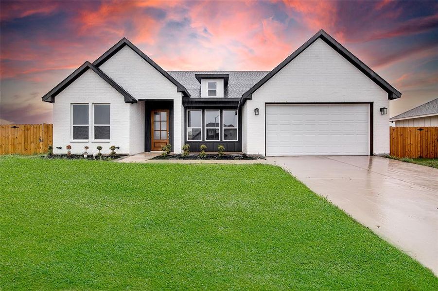 Modern farmhouse style home featuring brick siding, a garage, and driveway Modern farmhouse style home featuring brick siding, a garage, and driveway
