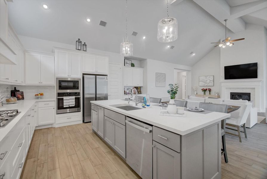 The kitchen offers a gas cooktop, a separate gas oven with a microwave above, and soft-close cabinets and drawers, all complemented by beautiful white cabinetry and a coordinating backsplash. The island also includes a convenient under-sink setup, adding both function and style to the heart of the home.