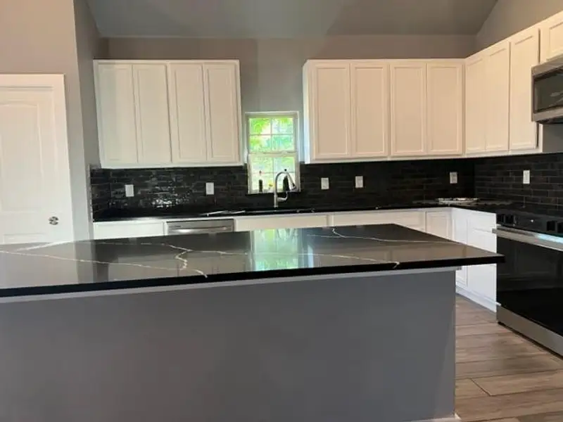 Kitchen featuring light hardwood / wood-style floors, stainless steel appliances, white cabinets, backsplash, and sink