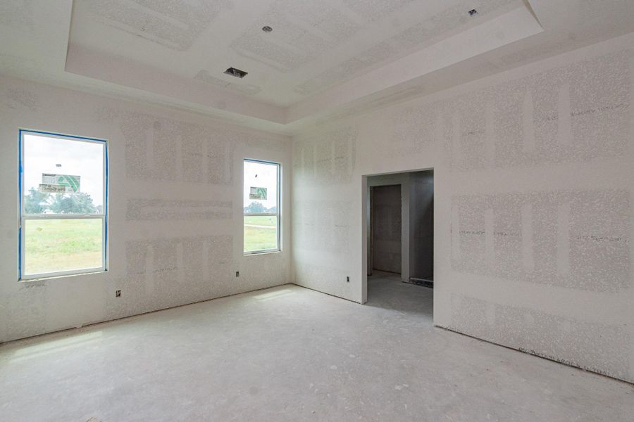 Bright and spacious primary bedroom with high ceilings and large windows, offering plenty of natural light and views of the surrounding greenery. Bright and spacious primary bedroom with high ceilings and large windows, offering plenty of natural light and views of the surrounding greenery.