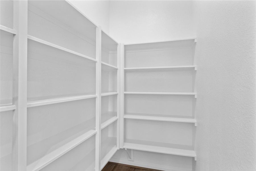 Spacious pantry featuring extensive built-in shelving, providing plenty of storage for all your kitchen essentials and bulk items. Spacious pantry featuring extensive built-in shelving, providing plenty of storage for all your kitchen essentials and bulk items.
