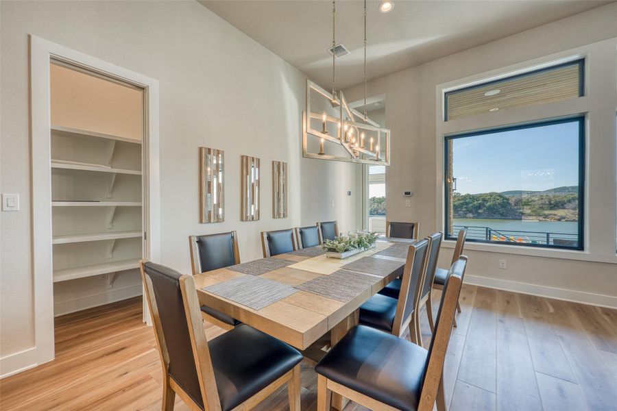 Dining area featuring light wood finished floors and a water view.
