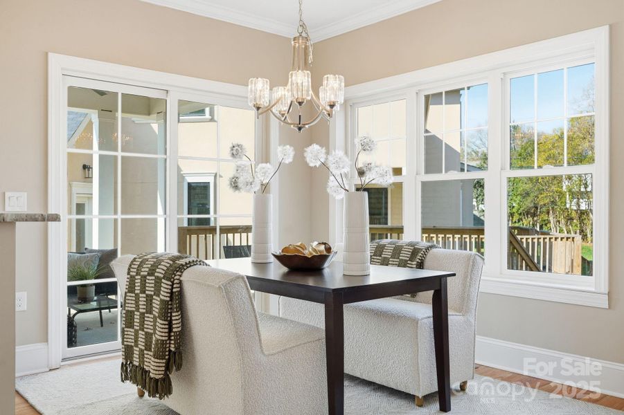 Elegant dining area with modern chandelier and views of the covered porch — perfect indoor/outdoor flow. Elegant dining area with modern chandelier and views of the covered porch — perfect indoor/outdoor flow.