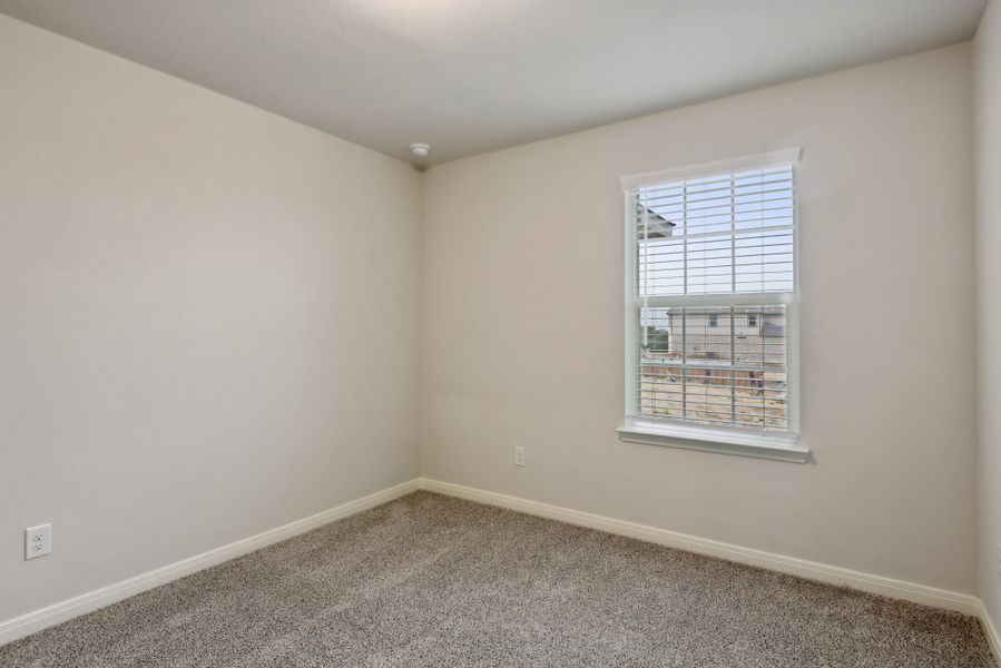 Guest bedroom in the Red River floorplan at a Meritage Homes community.