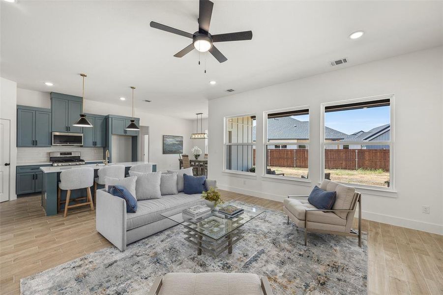 Living room featuring ceiling fan, sink, and light hardwood / wood-style floors