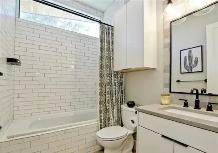 Full bathroom featuring tiled shower / bath combo and vanity Full bathroom featuring tiled shower / bath combo and vanity