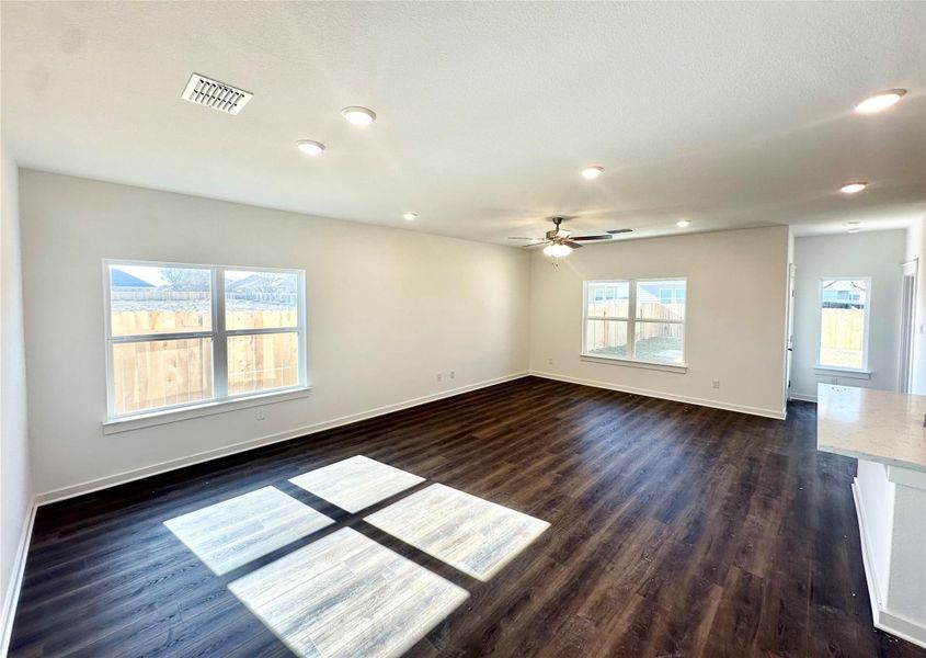 Empty room featuring dark wood-style floors, ceiling fan, and recessed lighting