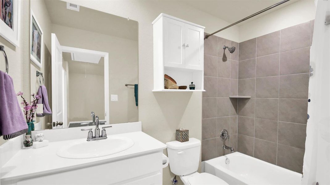 Bathroom featuring a white vanity with an integrated sink, polished chrome faucet, and a large mirror