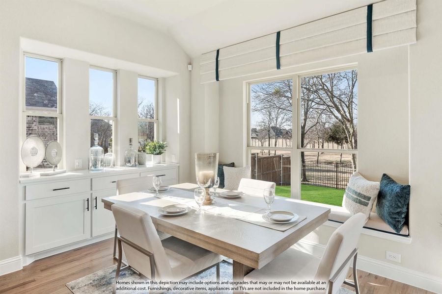 Bright dining area with vaulted ceiling, window bench seat, white cabinets, and large windows overlooking backyard Bright dining area with vaulted ceiling, window bench seat, white cabinets, and large windows overlooking backyard