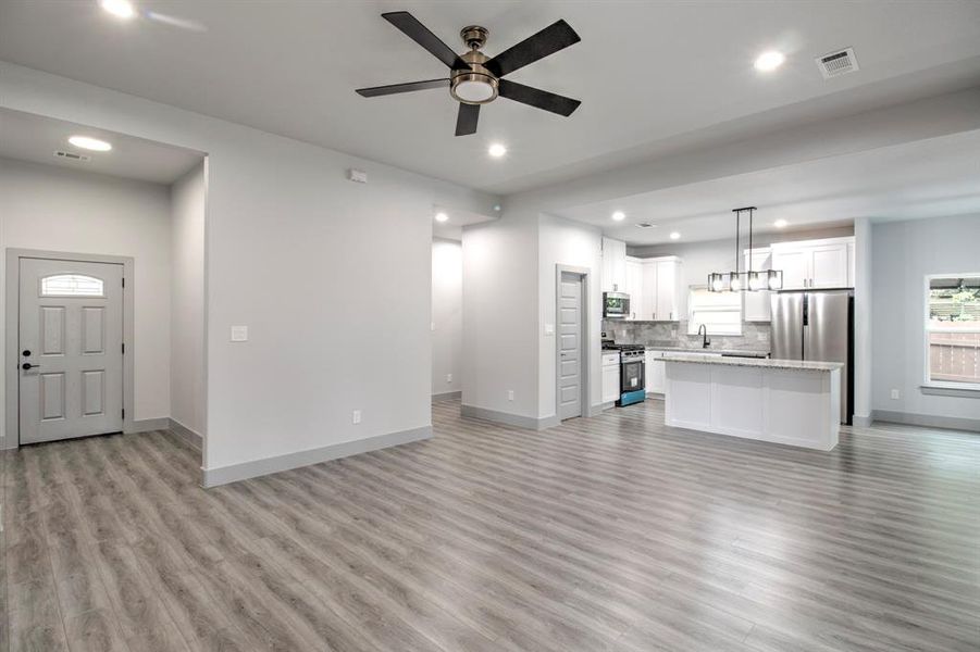 Unfurnished living room with light wood-type flooring, recessed lighting, and ceiling fan Unfurnished living room with light wood-type flooring, recessed lighting, and ceiling fan