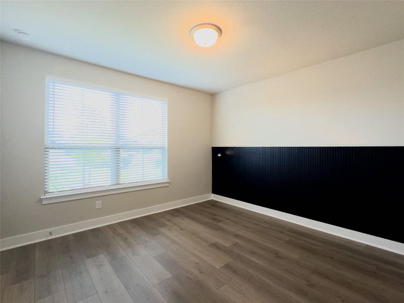 Spare room with baseboards and dark wood-style flooring Spare room with baseboards and dark wood-style flooring