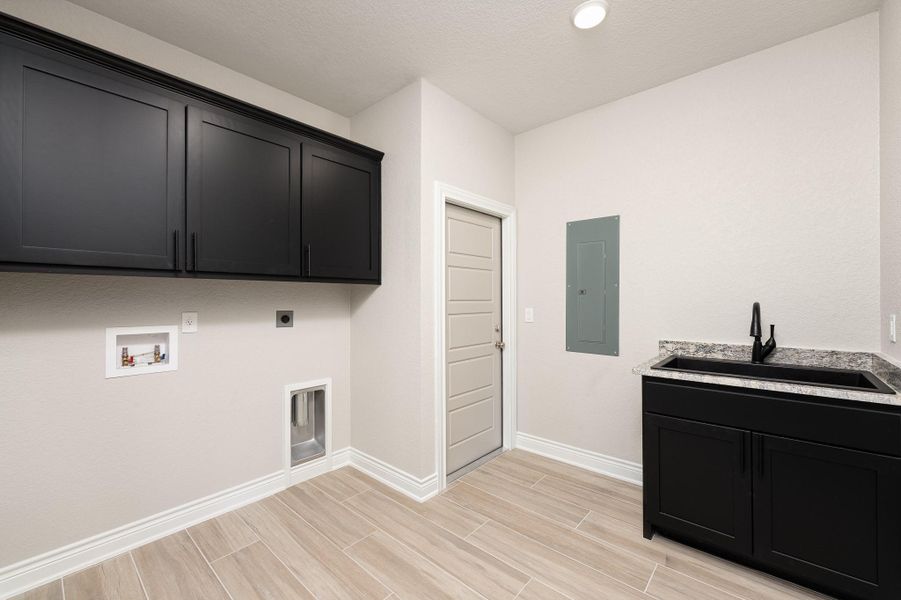 Laundry room with cabinet space, hookup for an electric dryer, electric panel, wood finish floors, and hookup for a washing machine Laundry room with cabinet space, hookup for an electric dryer, electric panel, wood finish floors, and hookup for a washing machine