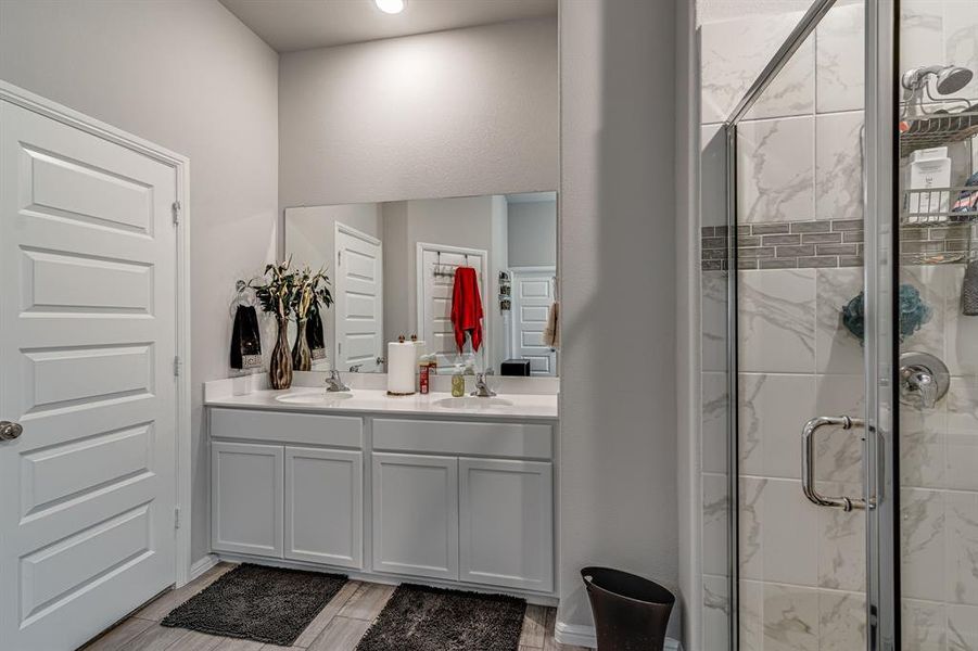 Bathroom featuring vanity, an enclosed shower, and hardwood / wood-style floors