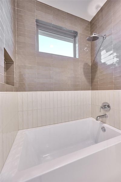 The Jack and Jill bathroom features a stylish shower/tub combo, with artisan oyster ceramic tile and rich chestnut ceramic tile adorning the shower. The Jack and Jill bathroom features a stylish shower/tub combo, with artisan oyster ceramic tile and rich chestnut ceramic tile adorning the shower.