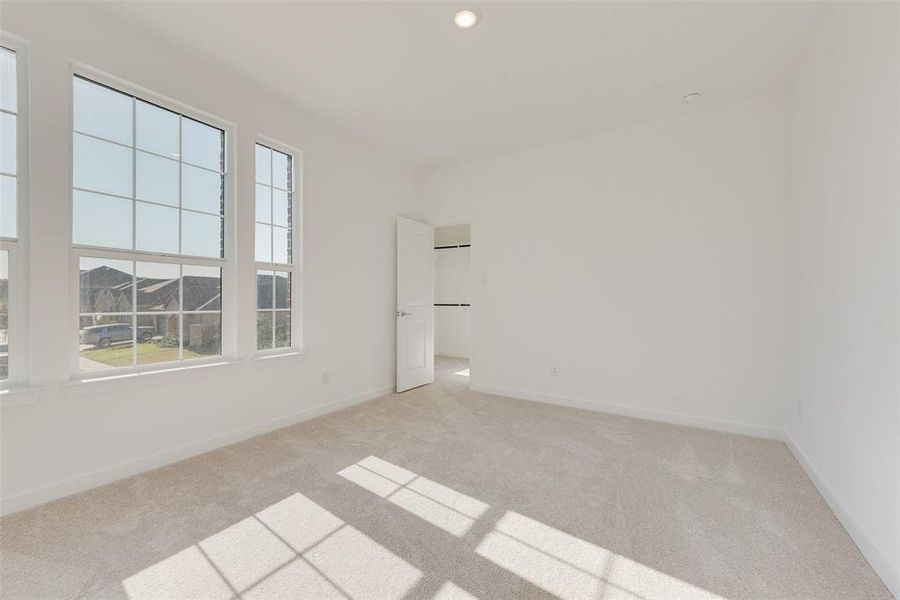 Spare room featuring light carpet and a healthy amount of sunlight