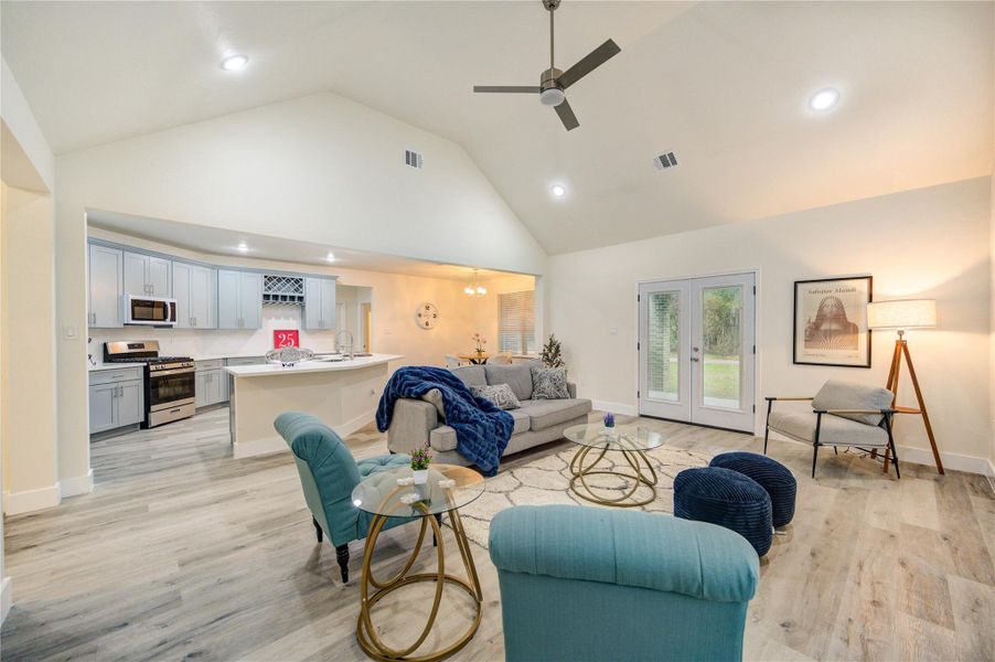 Discover the spacious and inviting living room, featuring high ceilings, modern lighting, and seamless flow into the kitchen. Perfect for relaxation and entertaining.