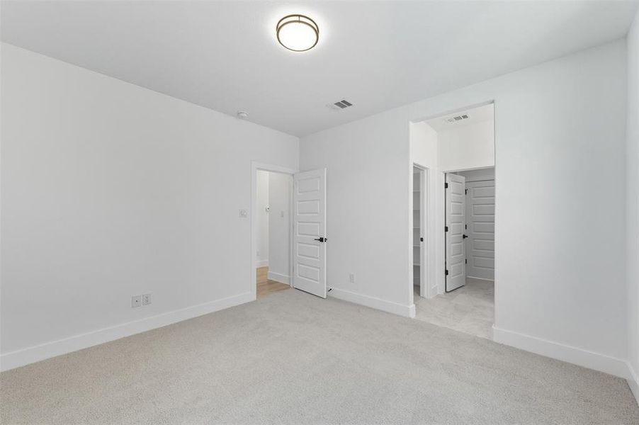 Unfurnished bedroom featuring light colored carpet and baseboards