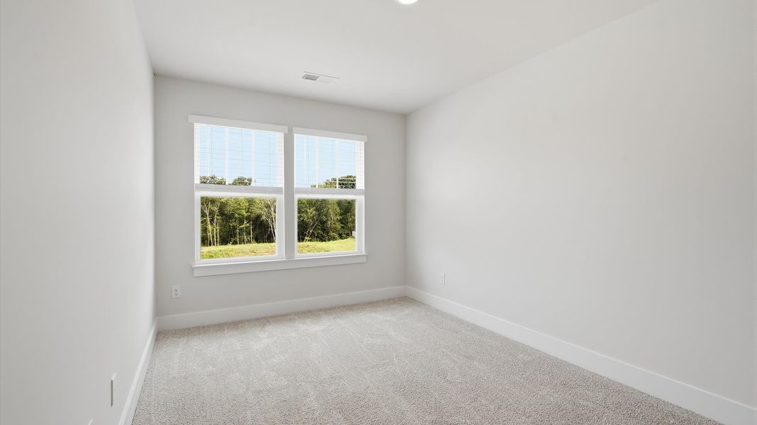 Elegant bedroom retreat featuring soft carpet and oversized windows that create a bright, welcoming space Elegant bedroom retreat featuring soft carpet and oversized windows that create a bright, welcoming space