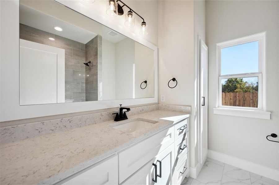 Bathroom with a tile shower and vanity