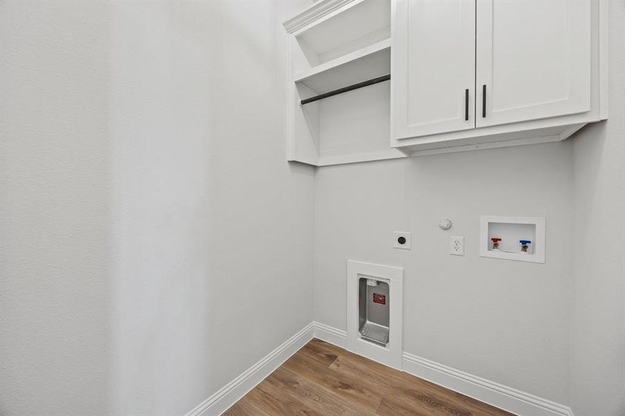Laundry area with gas dryer hookup, light wood-style floors, cabinet space, hookup for an electric dryer, and washer hookup