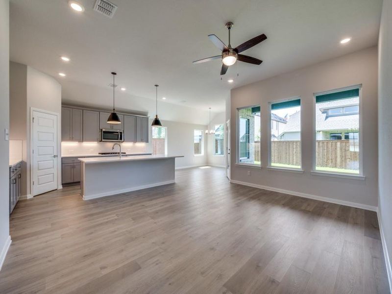 The open concept design of this wonderful home features beautiful flooring, walls of windows, a dream kitchen and so much more!