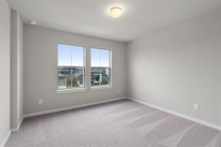A well-lit bedroom with fresh, neutral tones and a soft, patterned carpet.