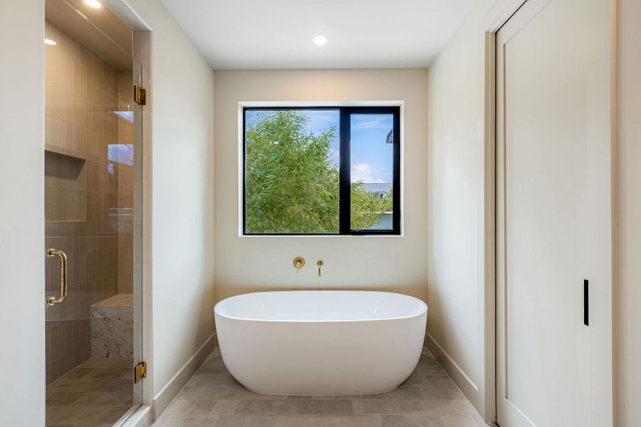 Full bath with a freestanding bath, a stall shower, and recessed lighting