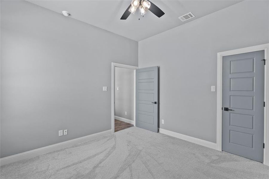 Carpeted empty room featuring ceiling fan