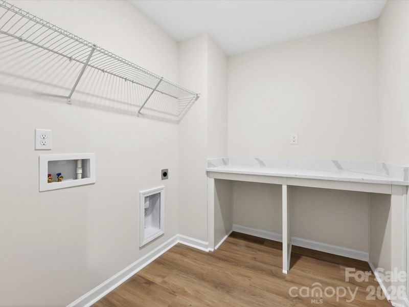second floor laundry room features a folding table with quartz countertop second floor laundry room features a folding table with quartz countertop