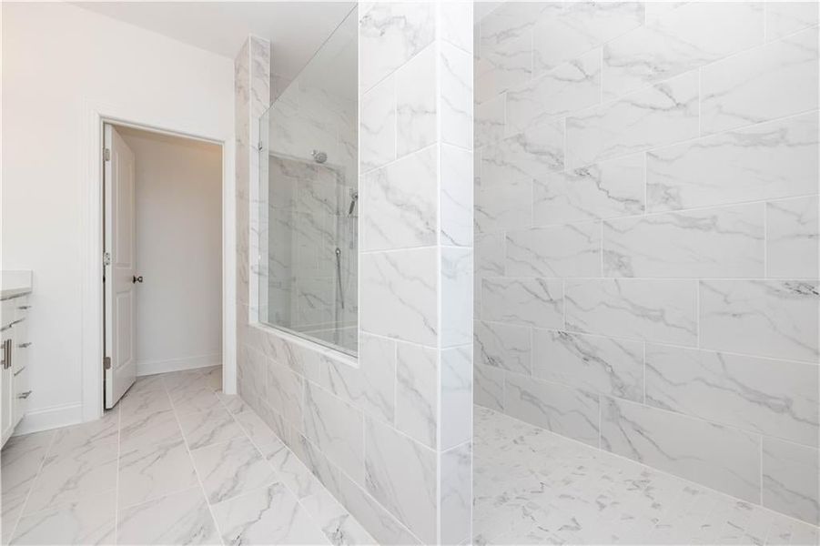 Primary bathroom with luxury walk in shower with drying area - all tile with glass see thru - Pictures represent a previously built home