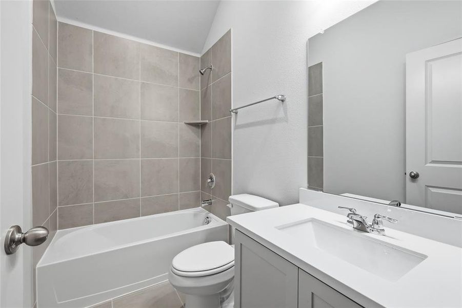 Full bath featuring vanity, shower / bathtub combination, and light tile patterned flooring