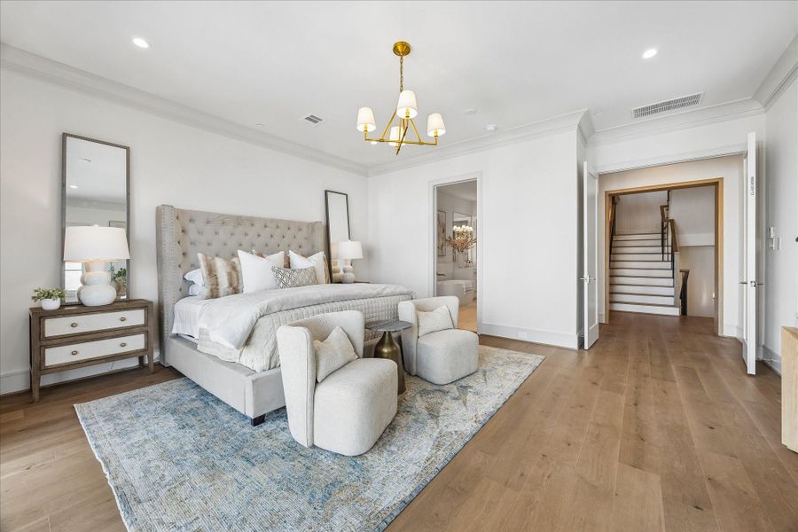 The primary bedroom has a wide entrance, framed with white oak. It opens onto a luxurious primary bathroom with a truly magnificent primary closet beyond.