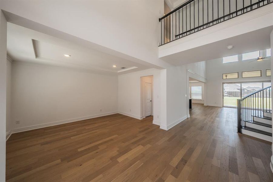 The property features high ceilings, hardwood flooring, and a staircase with a wrought iron railing