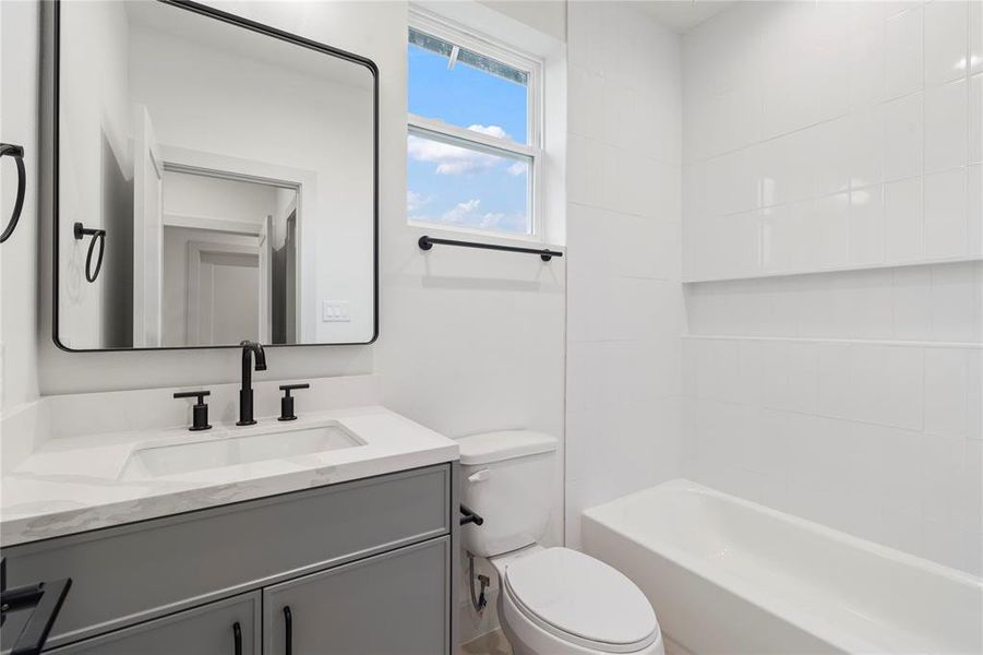 This private bath features high ceilings and ample lighting, creating a bright and spacious feel.