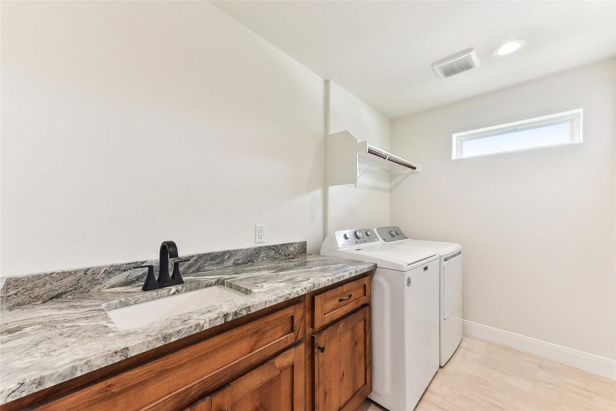 Laundry room featuring baseboards, a sink, visible vents, and independent washer and dryer Laundry room featuring baseboards, a sink, visible vents, and independent washer and dryer