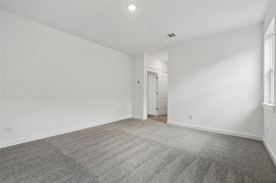 Carpeted spare room with baseboards