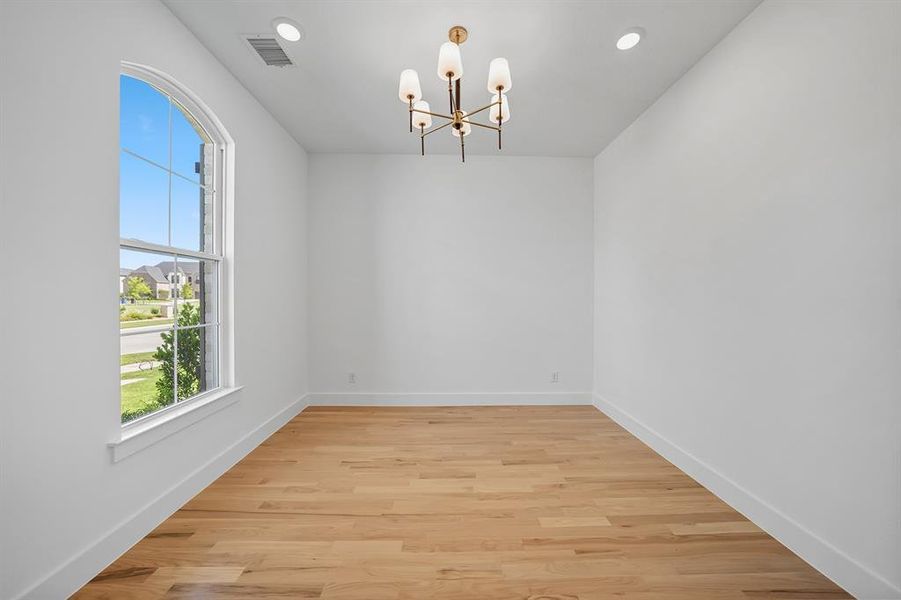 Unfurnished dining area featuring light wood-style floors, a chandelier, and recessed lighting