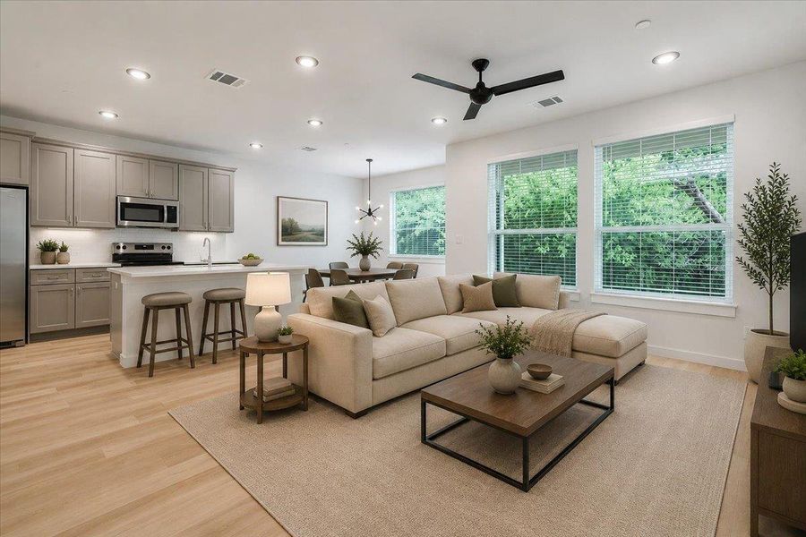 An inviting open-concept living space features a modern kitchen, a dining area, and a bright living room, perfect for entertaining.